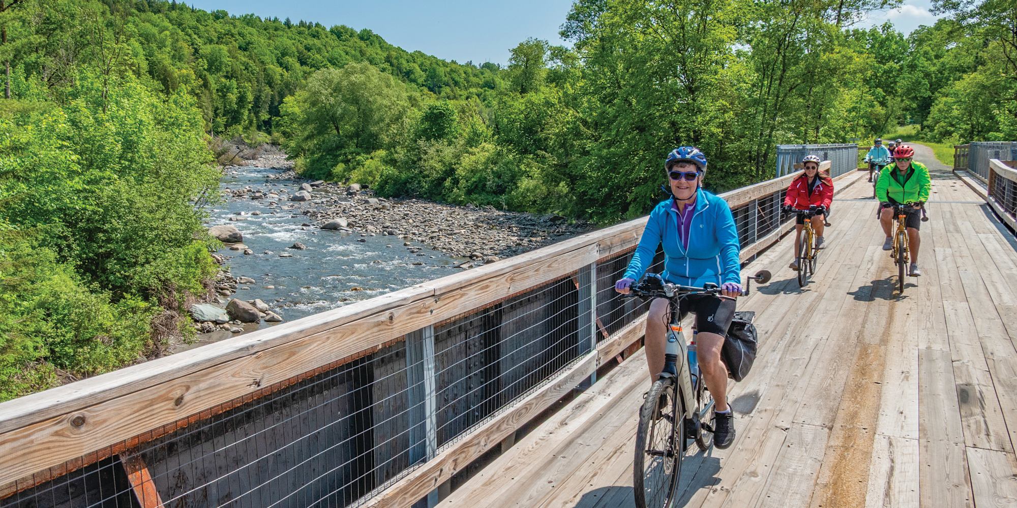 Guests cycling over bridge in Vermont