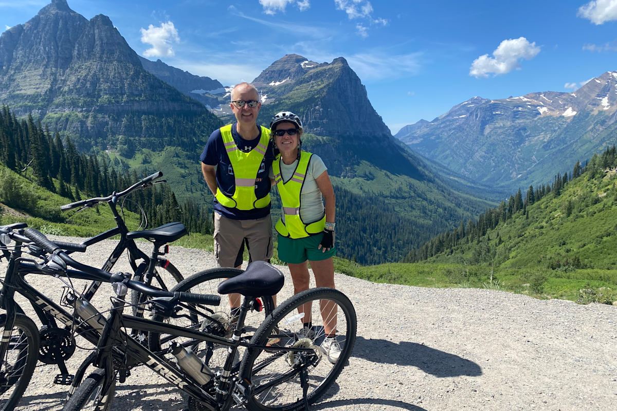 Guests overlooking a mountain valley with bikes and rugged alpine peaks Glacier National Park Bike Tour