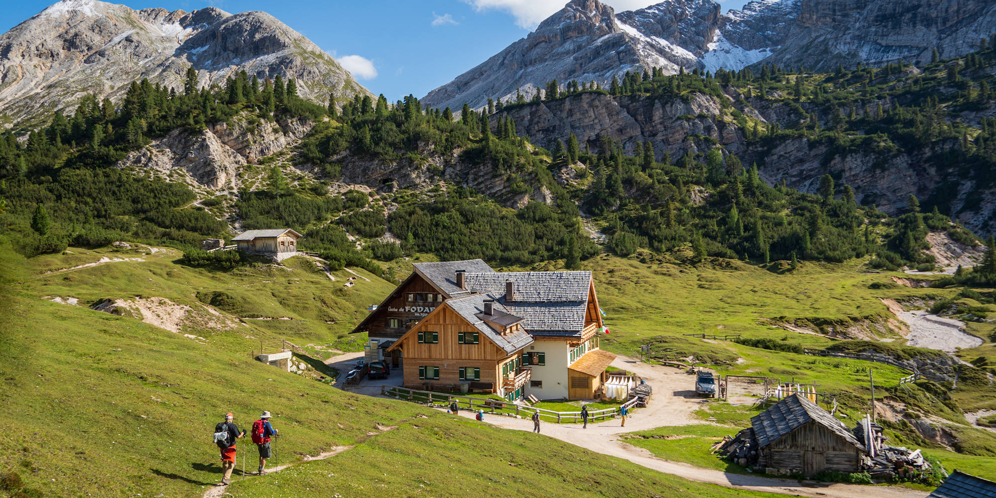 Guided hiking group approaching a mountain rifugio in the Dolomites